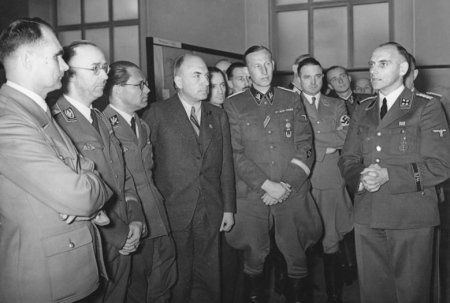 Der Agrarwissenschaftler Konrad Meyer (1901–1973; r.) mit Rudolf Heß, Heinrich Himmler, Philipp Bouhler, Fritz Todt und Reinhard Heydrich (erste Reihe, v.l.n.r.) auf der Ausstellung „Planung und Aufbau im Osten“ in Berlin am 20. März 1941.