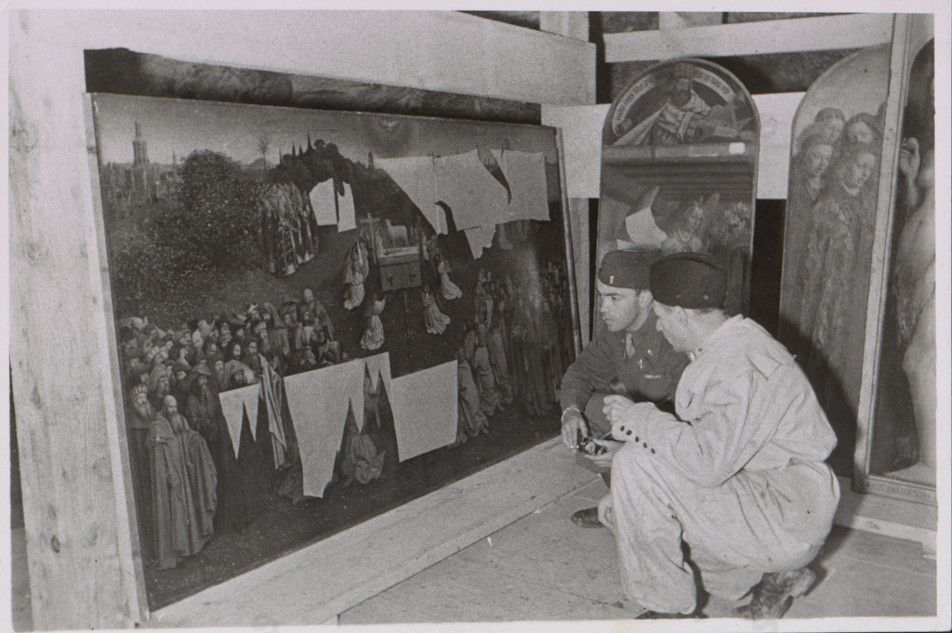 Angehörige der US-Streitkräfte bei der Begutachtung eines Altarteils des Genter Altars 1945, Wikimedia Commons, Gemeinfrei.