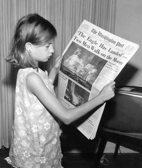 Foto: Ein Mädchen hält die Washington Post vom 21. Juli 1969 mit der Schlagzeile „The Eagle Has Landed – Two Men Walk on the Moon“ (Der Adler ist gelandet – zwei Menschen spazieren auf dem Mond) über die ersten Menschen auf dem Mond. Quelle: Wikimedia Commons. Public Domain.