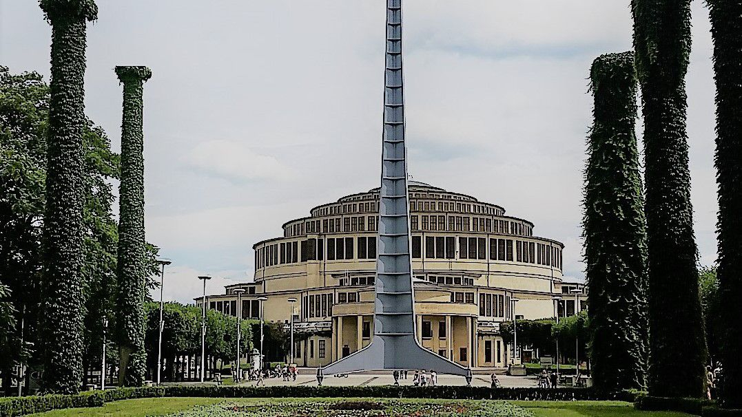 Der Architekt der Breslauer Jahrhunderthalle bezeichnete sein heute international gewürdigtes Bauwerk als „Kathedrale der Demokratie“. Der damals hochmoderne Stahlbetonbau wurde 1913 zum Anlass der 100jährigen Erinnerung an die preußischen Befreiungskriege gegen Napoleon errichtet. Anfang der 1980er Jahre hatten hier Anhänger der Gewerkschaftsbewegung Solidarność auf dem Gipfel der fast 100 m hohen, 1948 im Rahmen der Ausstellung „wiedergewonnene Westgebiete“ aufgestellten Iglica (Nadel) ihre Flagge gehisst. Die Jahrhunderthalle und die Nadel gelten als Wahrzeichen von Breslau. (Foto: J. Stoklasa)
