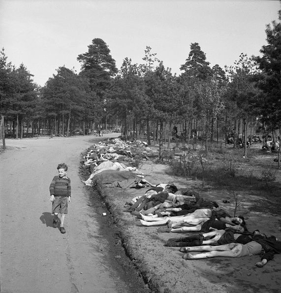 Young Boy, dressed in shorts, walks along a dirt road lined with the corpses of hundreds of prisoners who died at the Bergen-Belsen extermination camp, near the towns of Bergen and Celle, Germany, April 20, 1945. Photo by Georg Rodger/Life Magazine. Quelle: Getty Images.