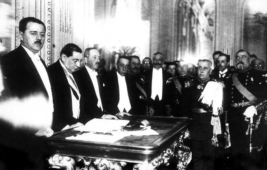 Foto: Der chilenische Präsident Arturo Alessandri (Zweiter v. l.) beim Unterschreiben der Verfassungsreform im Roten Saal des Palacio de La Moneda am 18. September 1925. Quelle: Wikimedia Commons, Public Domain.