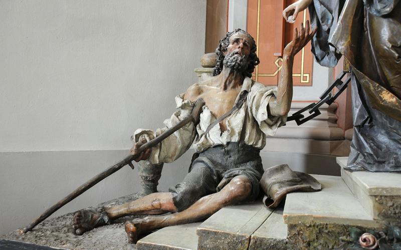Der Bettler von Ludwig Moroder der Gruppe der Heiligen Elisabeth des Rudolf Moroder in der Pfarrkirche St. Ulrich in Gröden.  © User: Wolfgang Moroder, Beggar Saint Elisabeth Group, 2008. Quelle: Wikimedia Commons (CC BY-SA 3.0)