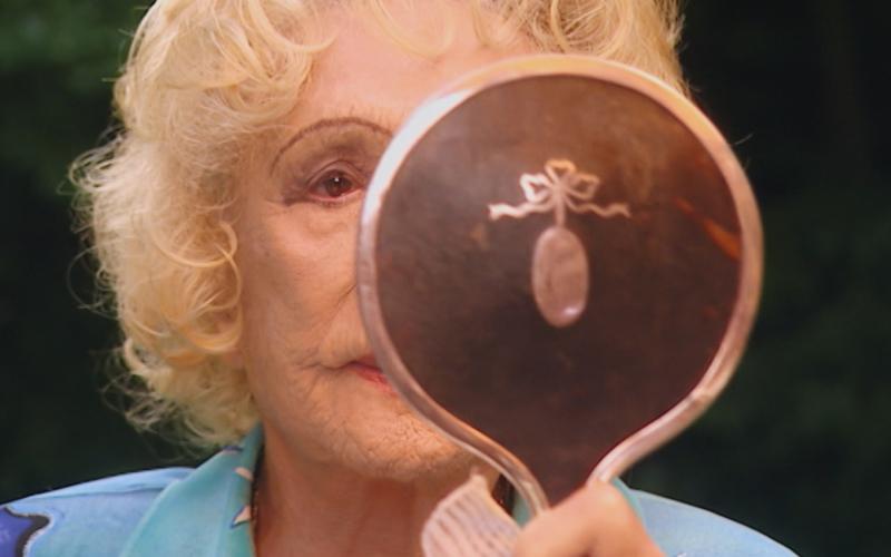 Leni Riefenstahl kontrolliert ihr Aussehen für die Aufzeichnung zur dreiteiligen Dokumentation „Speer und er“ von Regisseur Heinrich Breloer (1999) (© Bavaria Media)
