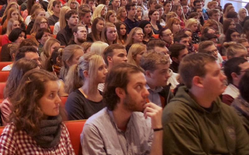 Student*Innen lauschen gebannt in einem überfüllten Vorlesungssaal