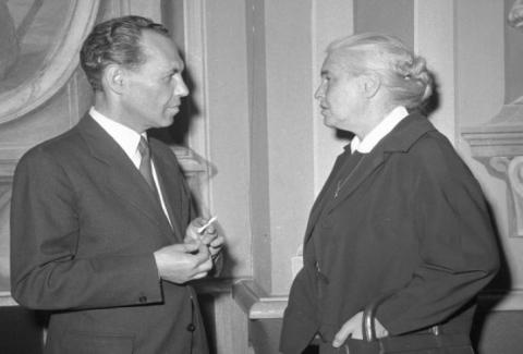 Schwarz-weiß Fotografie von Eduard Goldstücker und Anna Seghers die sich einander zugewandt unterhalten