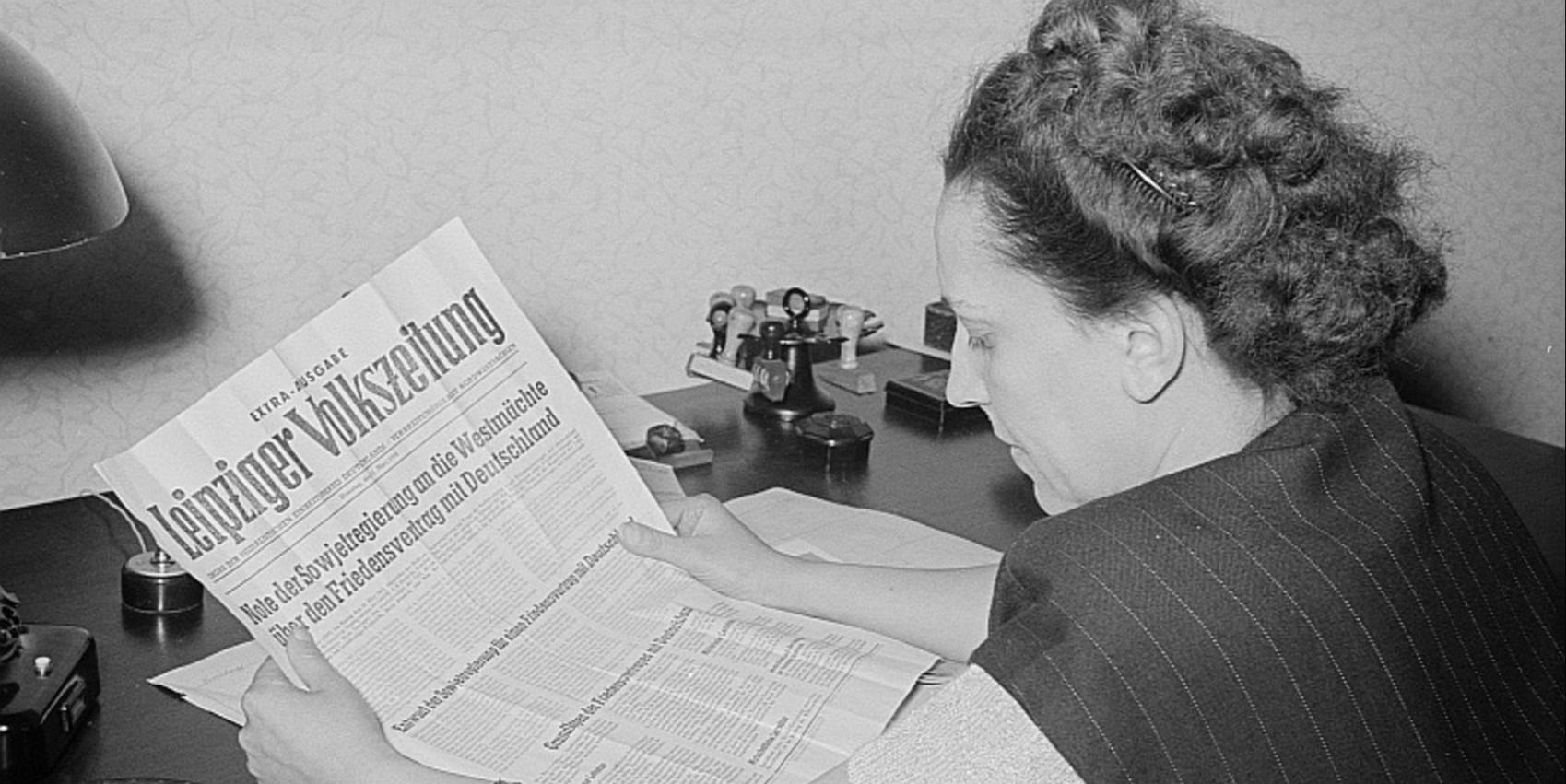 Porträt von Margarete Däumichen, die eine am 11. März 1952 zur Stalin-Note erschienene Sonderausgabe der Leipziger Volkszeitung liest.