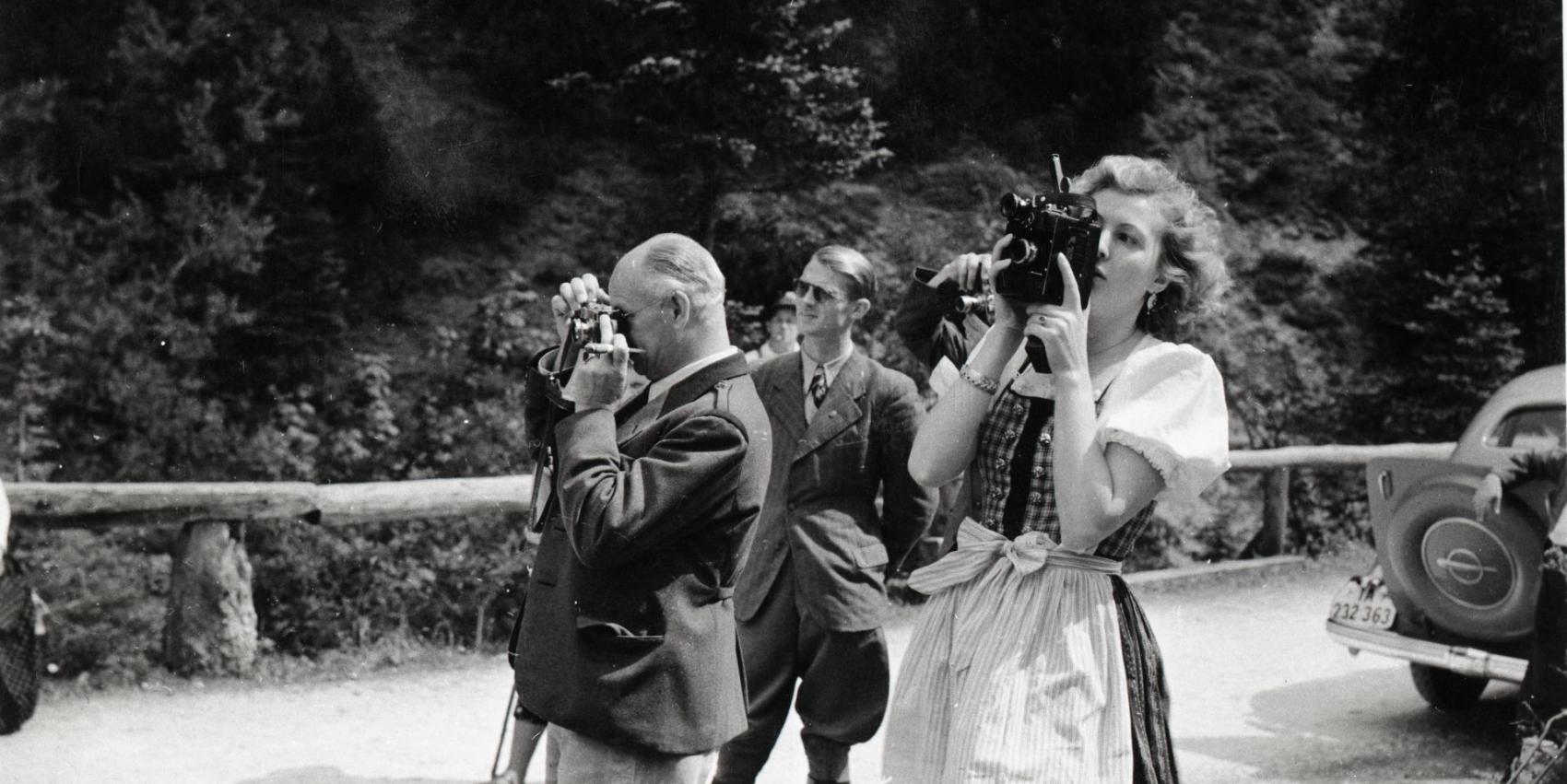 Eva Braun fotografiert, im Hintergrund Nazimänner, die ebenfalls fotografieren
