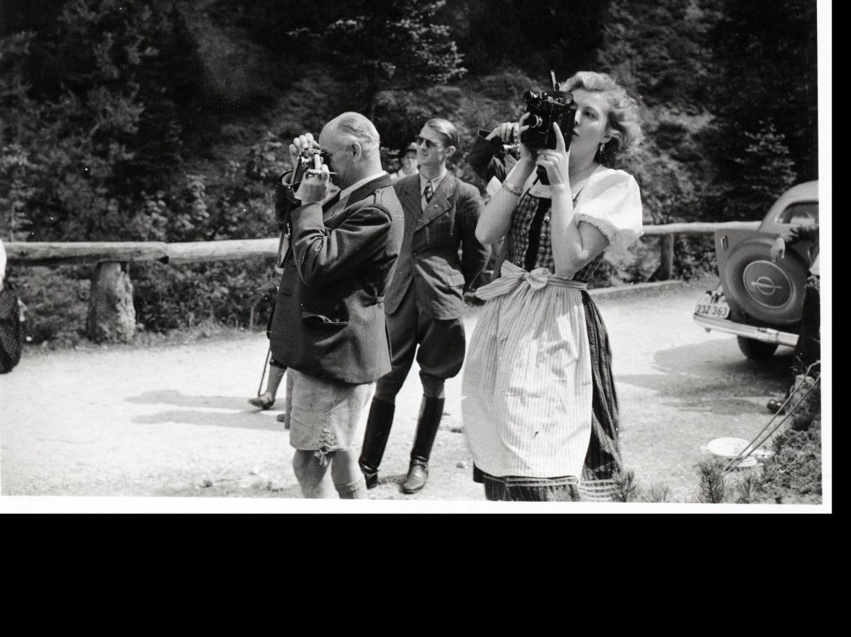 Eva Braun fotografiert, im Hintergrund Nazimänner, die ebenfalls fotografieren