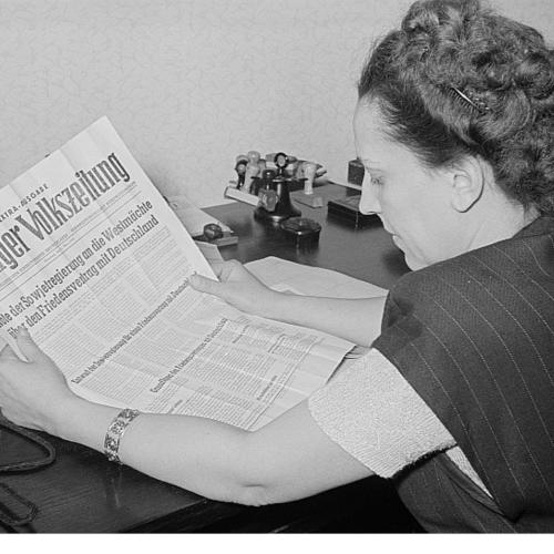 Porträt von Margarete Däumichen, die eine am 11. März 1952 zur Stalin-Note erschienene Sonderausgabe der Leipziger Volkszeitung liest.