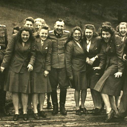 Nazi officers and female auxiliaries pose on a wooden bridge in Solahuette