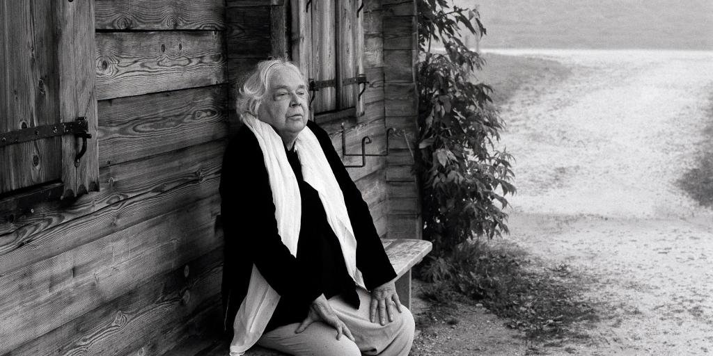 Thomas Harlan, auf einer Bank vor einer Hütte im Berchtesgadener Land sitzend, 2007.