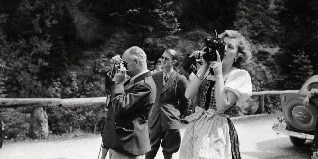 Eva Braun fotografiert, im Hintergrund Nazimänner, die ebenfalls fotografieren